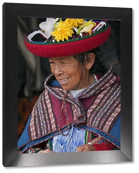 Peru, An old woman in traditional Indian costume with her round, saucer-shaped hat decorated with fresh