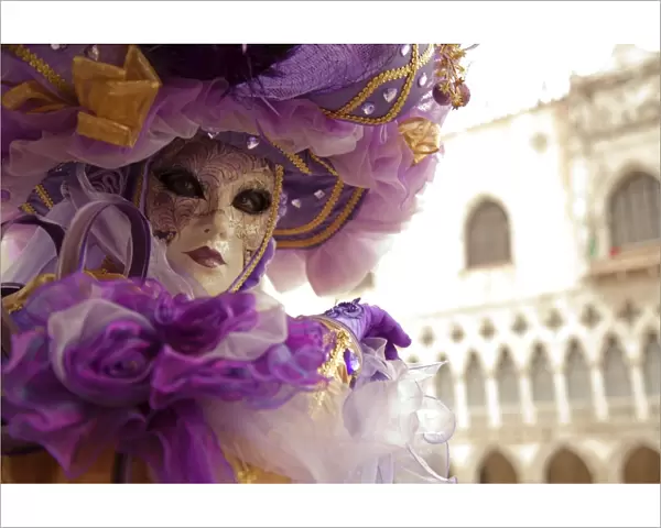 Venice, Veneto, Italy; A masked character in front of the Palazzo dei Dogi during Carnival