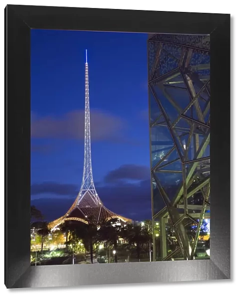 Australia, Victoria, Melbourne. Glass and steel architecture of Federation Square with the spire of the Theatres
