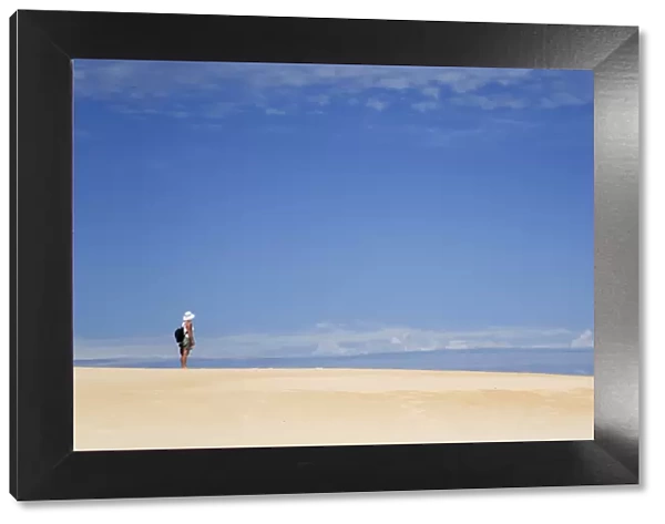 Australia, Tasmania, Strahan. A hiker looks out over Henty Dunes - a desert-like expanse of coastal sand dunes near