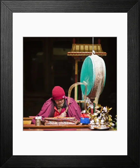 Framed Print : India, Ladakh, Hemis. Monk reciting prayers to the slow rhythm of a drum at Hemis Monastery