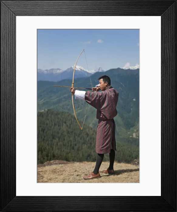Framed Print : Archery, datse, is a favourite national sport of the Bhutanese. Here an Archer practices his skills on the high Cheli La Pass using a traditional bamboo bow and arrow. Modern American-made bows are now used in