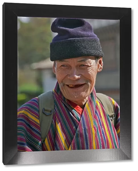 An old man at Trashigang wearing the traditional gho robe of all Bhutanese men