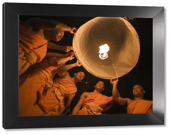 Thailand, Chiang Mai, San Sai. Monks launch a khom loi (sky lantern) during the Yi Peng festival