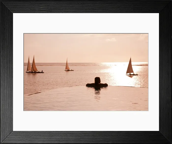 Framed Print : Zanzibar, Matemwe Bungalows. A tourist stands at the edge of an infinity pool watching the Dhows Framed Print : Zanzibar, Matemwe Bungalows. A tourist stands at the edge of an infinity pool watching the Dhows