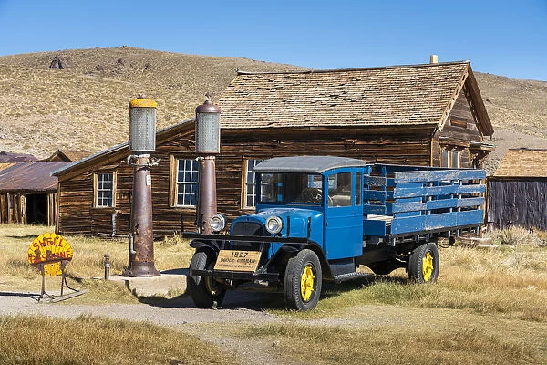 Abandoned blue old pickup truck and wooden deserted buildings in Bodie ghost town