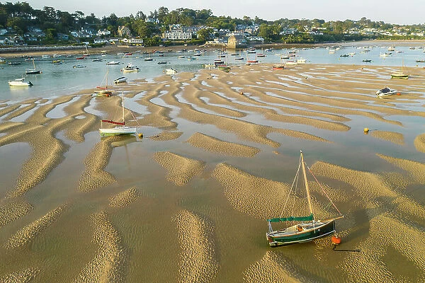 Aerial image of boats stranded on sand bar in the Camel Estuary near the village of Rock, Cornwall, England. Summer (August) 2022