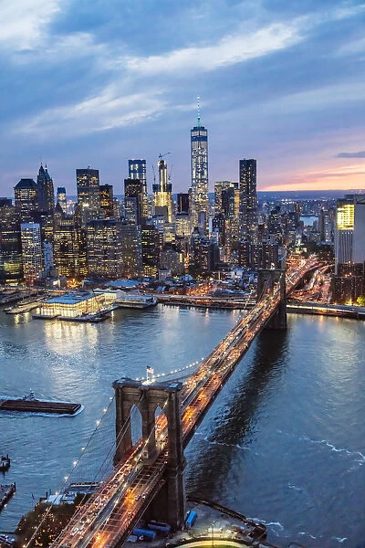 Aerial of lower Manhattan skyline and Brooklyn bridge at dusk, New York, USA
