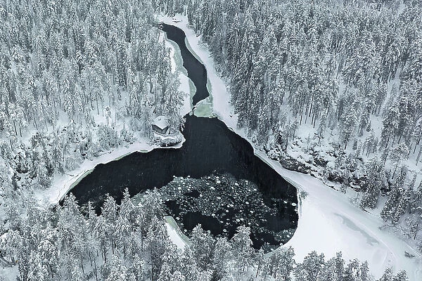 Aerial of riverside hut & snow-covered forest, Oulanka National Park, Finland