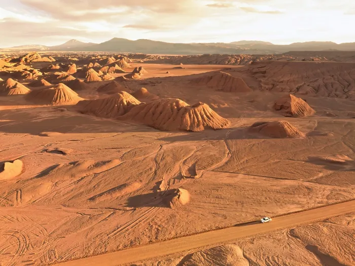 Framed Print : Aerial view of a 4x4 off-road vehicle on a dirty road in 'Los Colorados' at sunset, Devil Desert (Labyrinth Desert), Puna de Atacama, Tolar Grande, Salta, Argentina