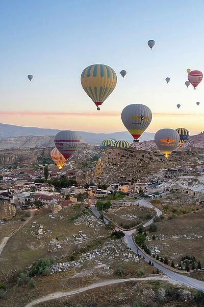 Aerial view of Cavusin and hot air balloons at dawn, Avanos District, Nevsehir Province, Cappadocia, Central Anatolia Region, Turkey