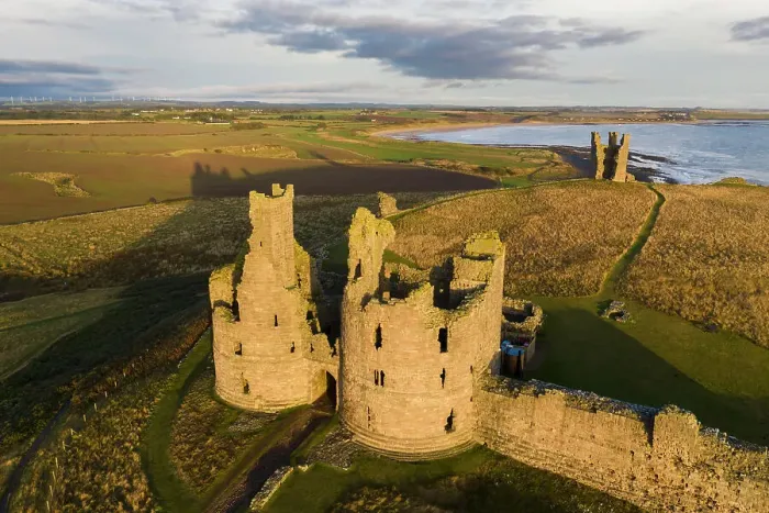 Framed Print : Aerial view of Dunstanburgh Castle on the Northumbrian coast, Embleton, Northumberland, England. Autumn (October) 2021