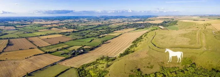 Framed Print : Aerial view of the famous White Horse below Bratton Camp, an Iron Age hillfort near
