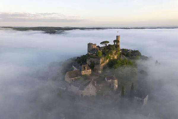 An aerial view of the hilltop village of Turenne at sunrise surrounded by mist, Correze