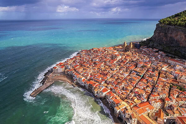 Aerial view of the historic centre of Cefalu with the rock in the background and red tile roofs, daytime, Cefalu, Palermo province, Tyrrhenian sea, Sicily, Italy