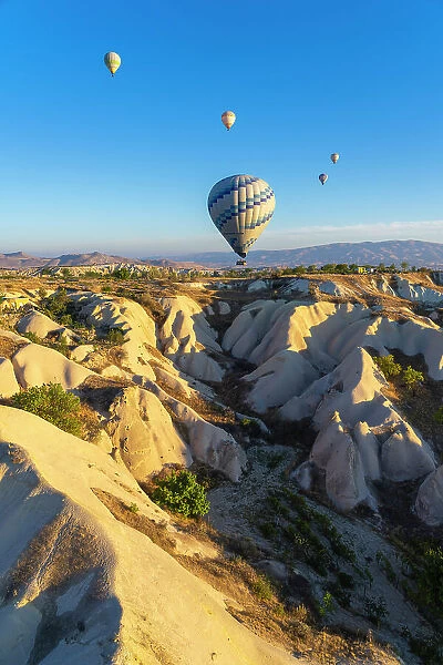 Aerial view of hot air balloon over rock formations at sunrise, Goreme, Goreme Historical National Park, Nevsehir District, Nevsehir Province, UNESCO, Cappadocia, Central Anatolia Region, Turkey