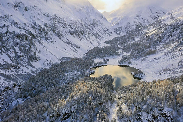 Aerial view of Lake Cavloc after an autumn snowfall, Maloja Pass, Bregaglia Valley