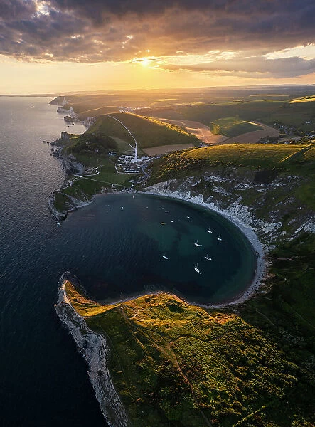 Aerial view of Lulworth Cove at sunset with boats, Durdle Door, Dorset, United Kingdom