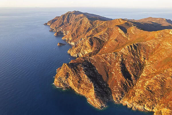 Aerial view of the rugged coast of the island of Capraia at sunset, Tuscan Archipelago National Park, Livorno province, Tuscany, Italy