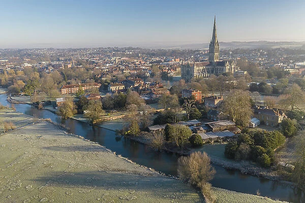 Aerial view of Salisbury city and cathedral from Harnham Water Meadows, Wiltshire, England. Winter (February) 2023