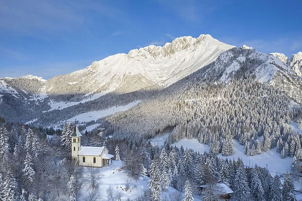 Aerial view of the Silvestri church and the Presolana massif after a winter sunrise