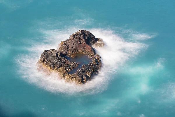 Aerial view of small rock island amongst waves, Madeira, Portugal
