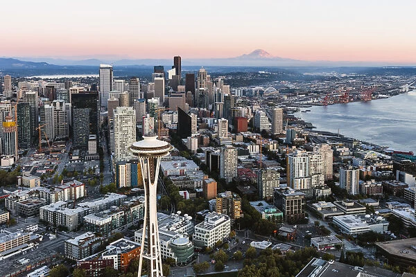 Aerial view of The Space Needle and downtown skyline at sunset with Mt Rainier in
