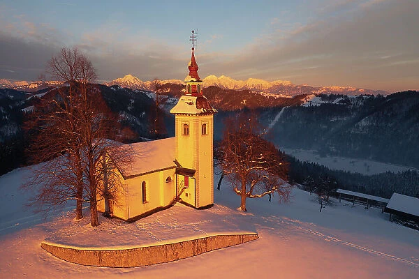 Aerial view of St Thomas Church and the Kamnik Alps, Rantovse, Slovenia at sunset