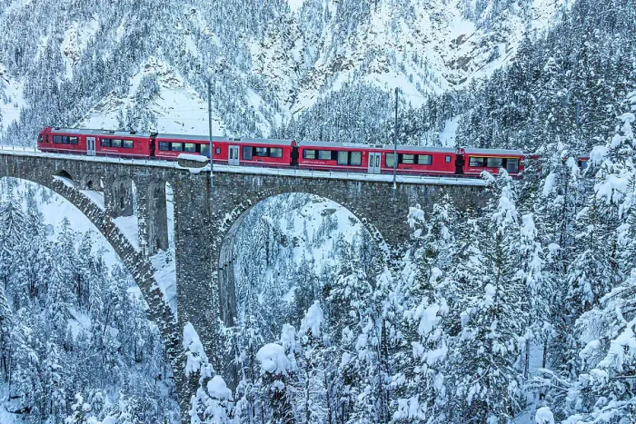 Framed Print : Aerial view of the Swiss red train traveling on Wiesen viaduct across snowy frozen woods, Davos, Graubunden canton, Switzerland Framed Print : Aerial view of the Swiss red train traveling on Wiesen viaduct across snowy frozen woods, Davos, Graubunden canton, Switzerland