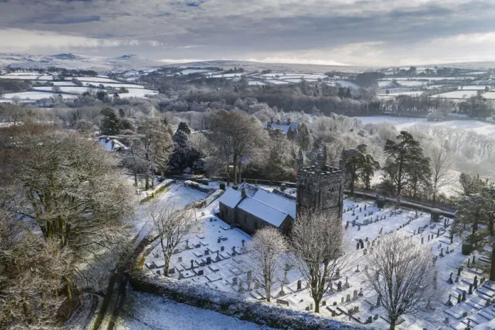 Framed Print : Aerial vista of St Petrocs Church on a snowy winter morning in the Dartmoor village of Framed Print : Aerial vista of St Petrocs Church on a snowy winter morning in the Dartmoor village of