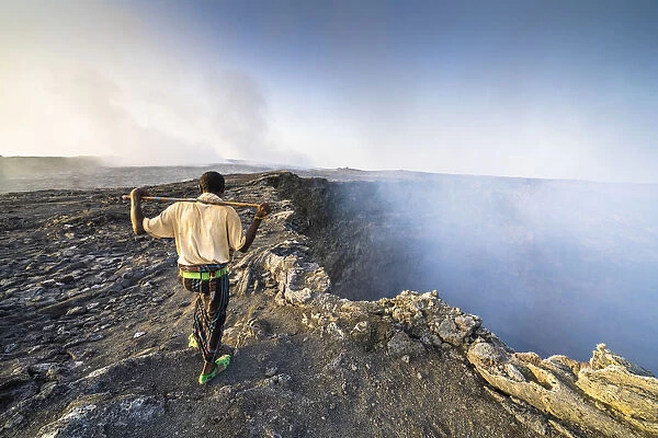 Afar man looking at the smoke coming out from Erta Ale volcano caldera