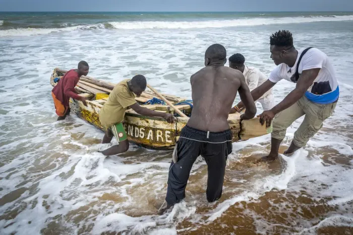 Framed Print : Africa, Benin, Grand Popo. A group of fishermen taking their boat into the water Framed Print : Africa, Benin, Grand Popo. A group of fishermen taking their boat into the water