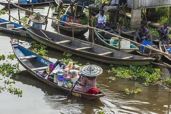Africa, Benin, Lake Nokoua. A woman drives her canoe to the market in the famous