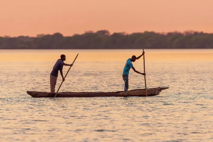 Framed Print : Africa, Botswana, Chobe River. Two Fishermen with traditional mokoro canoe on the river at sunset