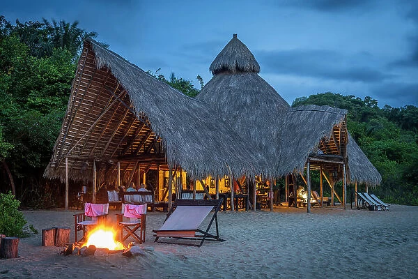 Africa, Tanzania, Mahale Mountains National Park. The main building of Greystoke Mahale during the blue hour with the fireplace