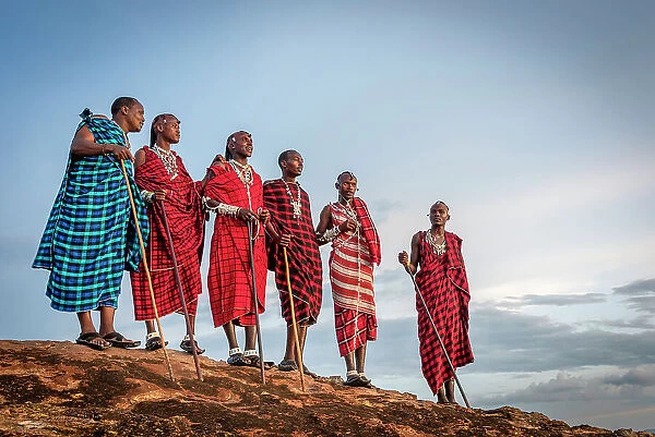 Africa, Tanzania, Manyara Region. A group of Msai men standing on a rock in the afternoon light