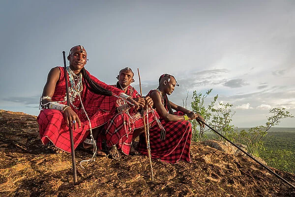 Africa, Tanzania, Manyara Region. Msai warriors on a rock overlooking the landscape towards the plain of Tarangire National park