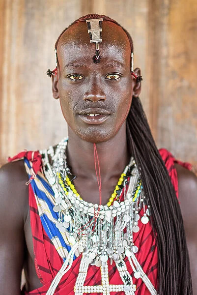 Africa, Tanzania, Manyara Region. Young warrior posing for a portrait with traditional jewellery and dress