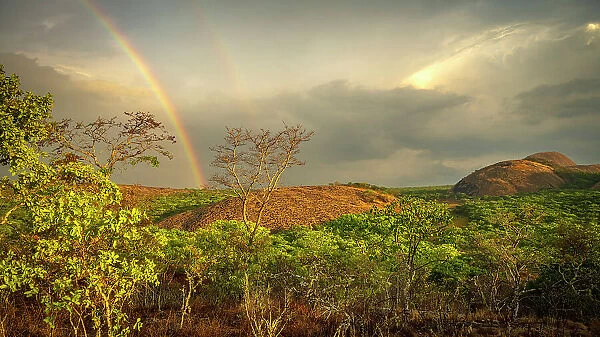 Africa, Zambia, Northern Zambia, Mutinondo Wilderness. On a hike in the rocky landscape at sunset with a rainbow