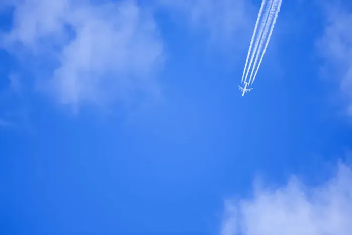 Framed Print : An airplane flies across a blue sky leaving vapour trails Framed Print : An airplane flies across a blue sky leaving vapour trails