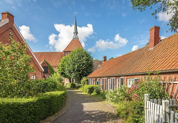Alley and church in the village of Rysum, Krummhoern, East Frisia, Lower Saxony, Germany