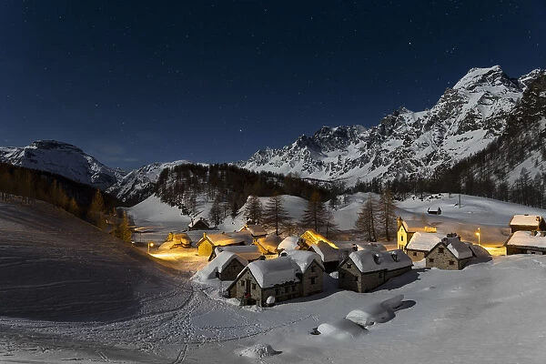 The Alp Crampilo (Alpe Crampiolo) covered with snow in a full moon night in winter