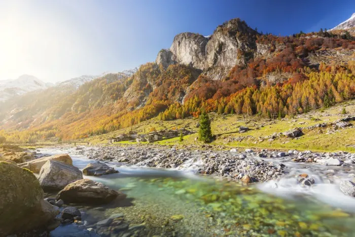 Framed Print : Alpine torrent with view on the alpine village in autumn Framed Print : Alpine torrent with view on the alpine village in autumn