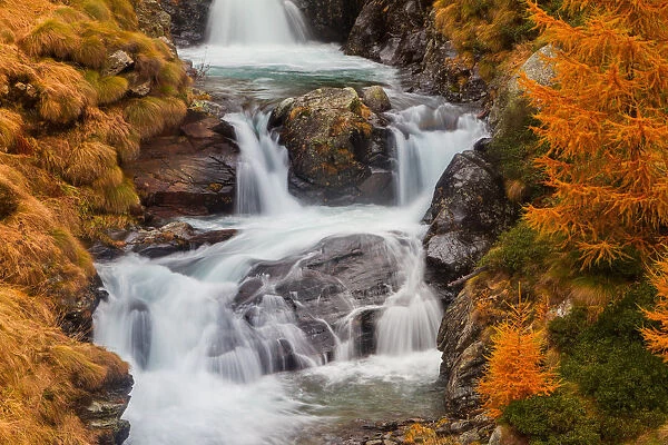Alpine waterfall in autumn. Lombardy, Italy