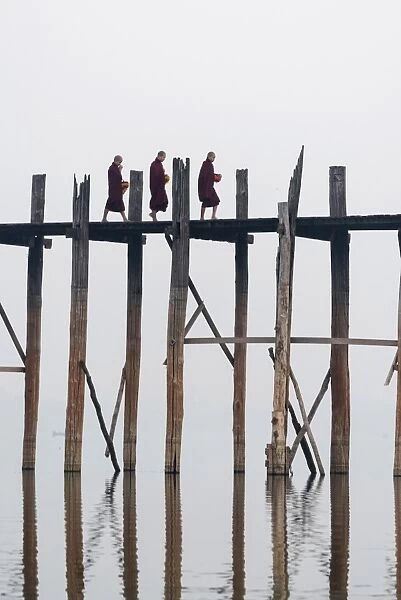 Amarapura, Mandalay region, Myanmar. Monks walking on the U Bein bridge
