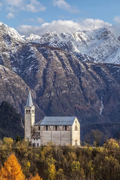 Ancient church of Valle di Cadore and snowcapped Dolomiti di Oltrepiave on the