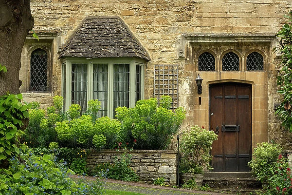 Ancient house front in the Cotswolds town of Burford, Gloucestershire, England. Spring (May) 2019