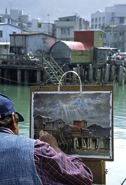 An artist at work painting the stilt house village