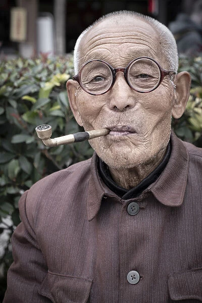 Asia, China, Shaanxi Province, Xian, local man smoking a traditional pipe