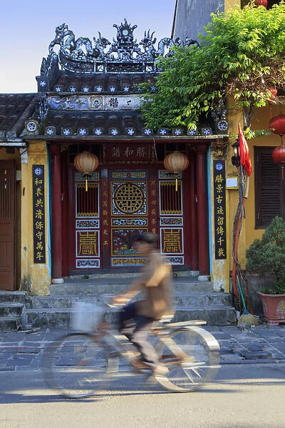 Asia, South East Asia, Vietnam, Hoi An, cyclist passing a temple in the old centre
